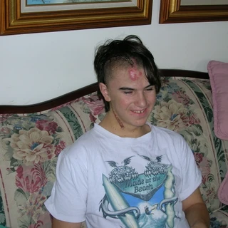 Alex smiling sitting on the couch at home