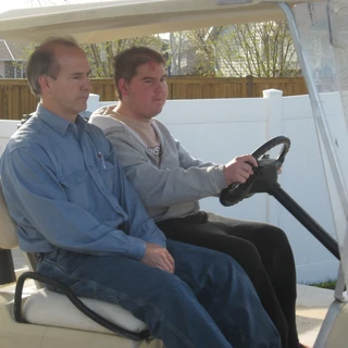 Alex and Dad driving the golf cart