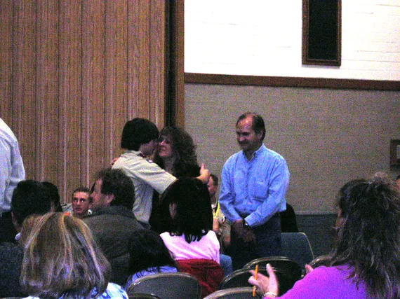 Alex at a scout ceremony hugging mom